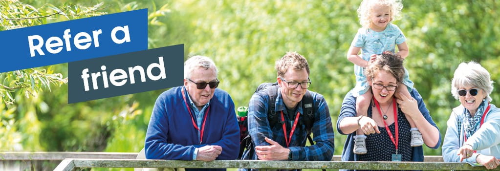 Refer a friend banner. Family enjoying a Boundless Members-day at the Wildfowl and Wetlands Trust. Mother and grandmother pointing to pond.